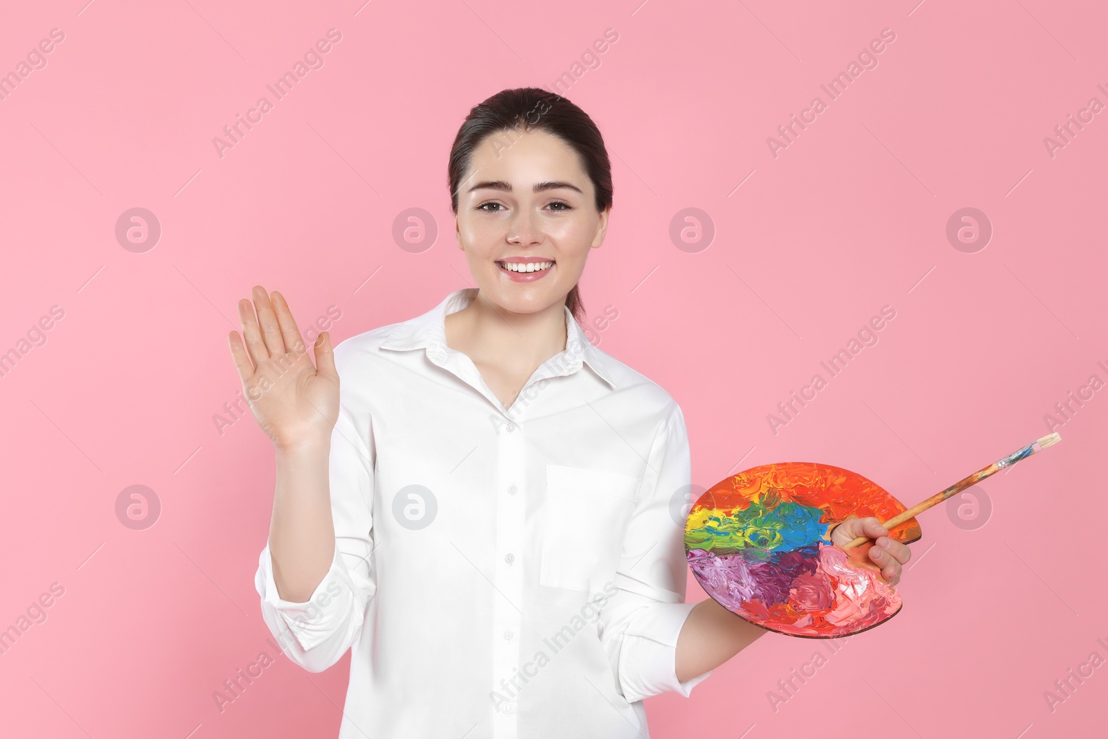 Photo of Woman with painting tools on pink background. Young artist