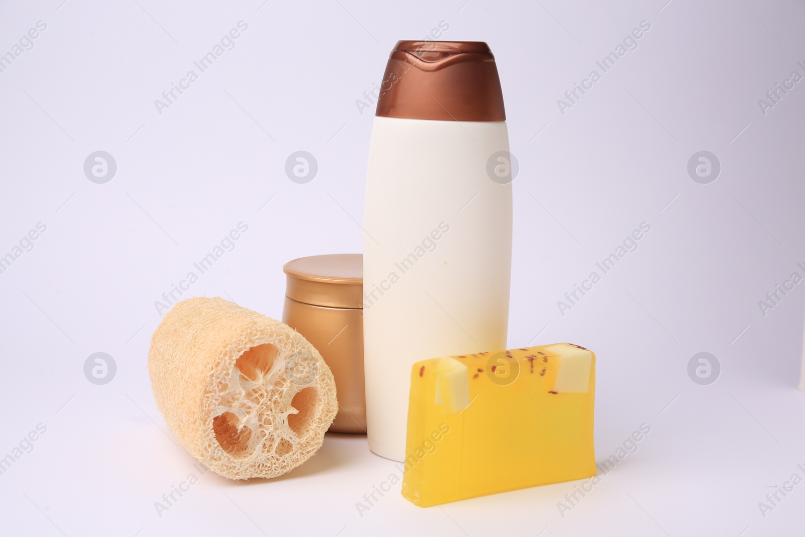 Photo of Natural loofah sponge and cosmetic products on white background