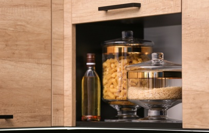 Shelf with raw cereals in modern kitchen