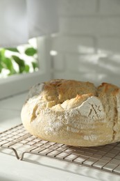 Freshly baked sourdough bread on white wooden table indoors