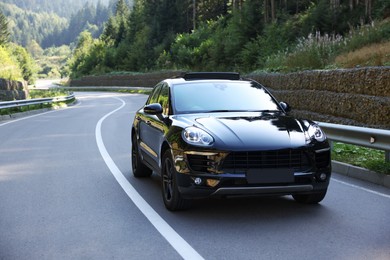 Picturesque view of asphalt road with modern black car outdoors