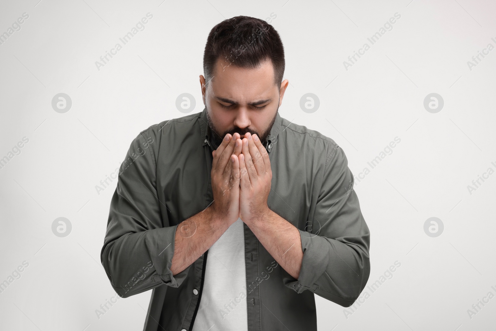 Photo of Sick man coughing on white background. Cold symptoms