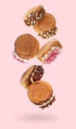 Image of Delicious round croissants in air on pink background. Puff pastry