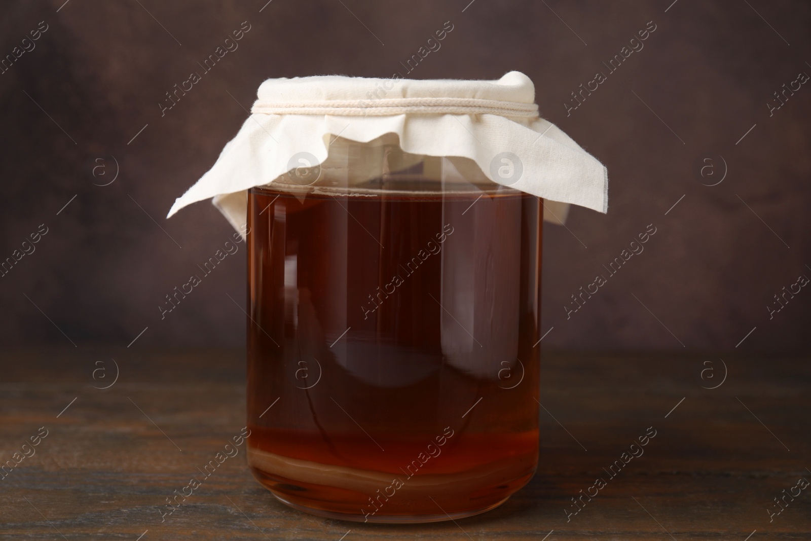 Photo of Tasty kombucha in glass jar on wooden table