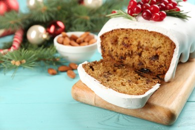 Photo of Traditional classic Christmas cake decorated with cranberries and rosemary on turquoise wooden table