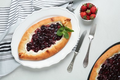 Delicious sweet cottage cheese pastry with cherry jam served on light table, flat lay