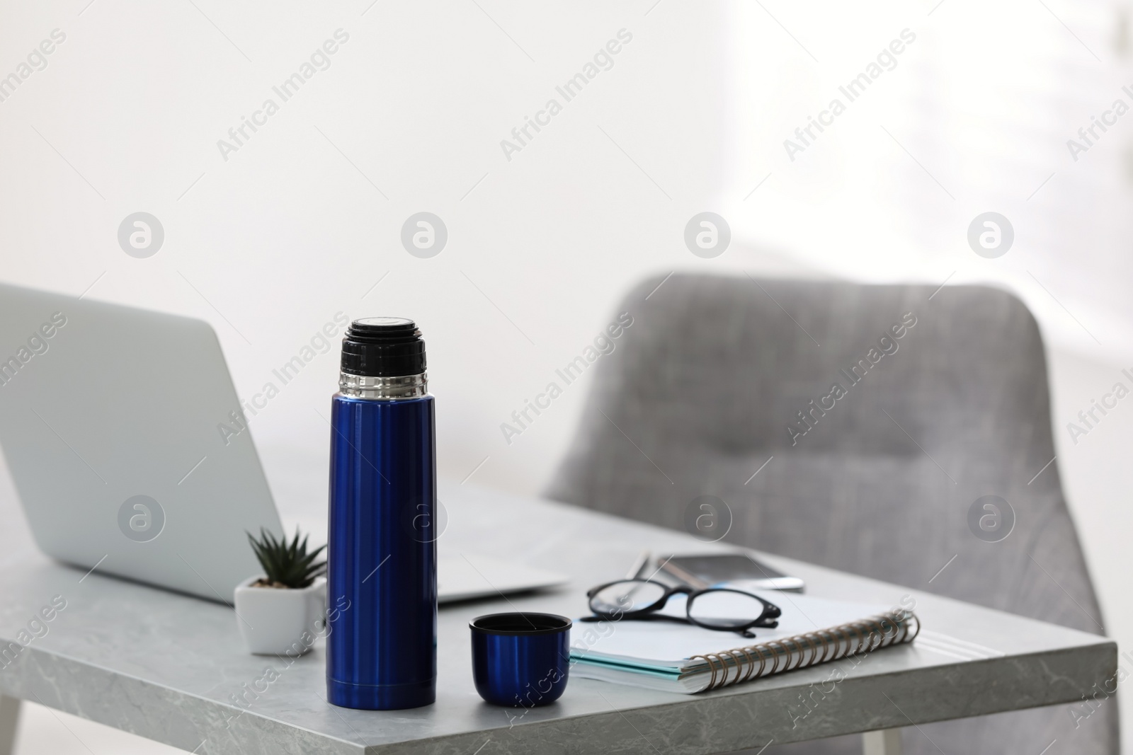 Photo of Thermo bottle on table in modern office