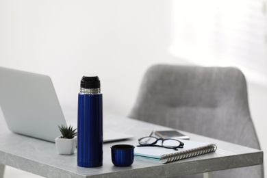 Thermo bottle on table in modern office