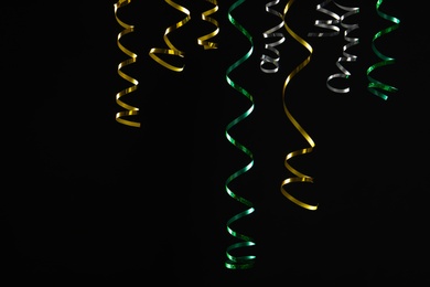 Many colorful serpentine streamers on black background