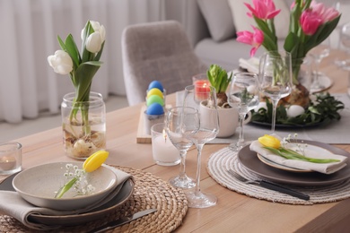 Photo of Beautiful Easter table setting with beautiful flowers indoors