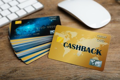 Image of Cashback and credit cards on wooden table, closeup view