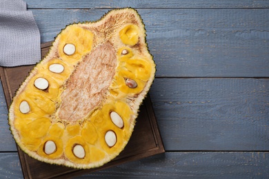 Photo of Delicious exotic jackfruit on grey wooden table, top view. Space for text