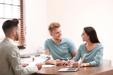 Insurance agent consulting young couple in office