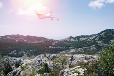 Image of Airplane flying over beautiful mountains on sunny day