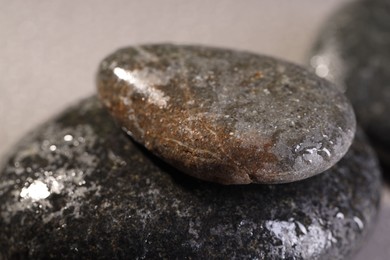 Wet spa stones on grey background, closeup