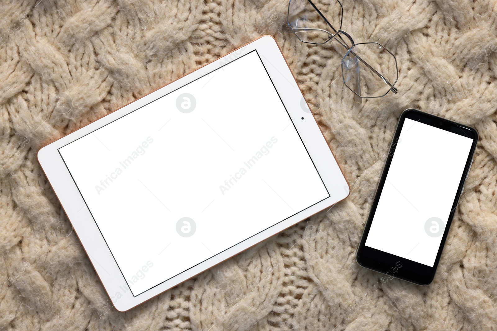 Photo of Modern tablet and smartphone on beige fabric, top view. Space for text