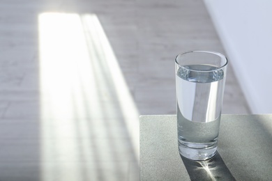 Photo of Glass of pure water on table indoors. Space for text