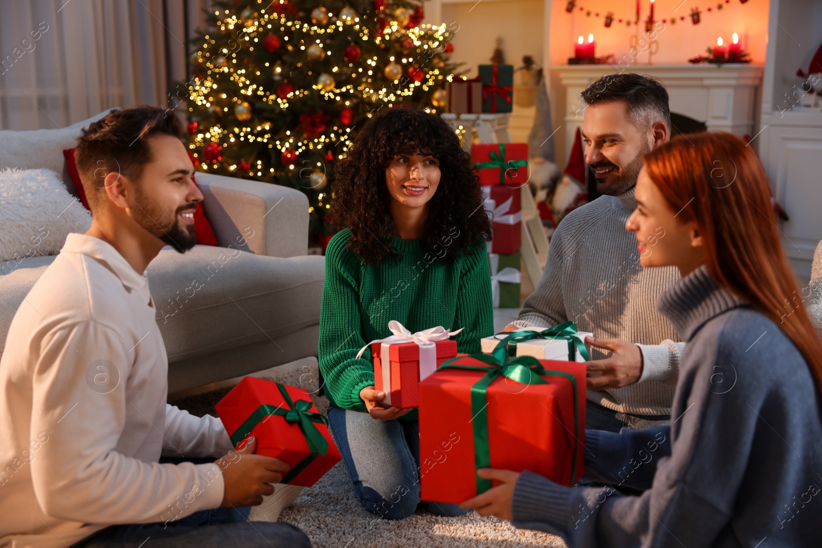 Photo of Christmas celebration. Happy friends exchanging gifts at home