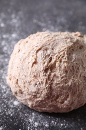 Photo of Fresh sourdough and flour on grey table, closeup