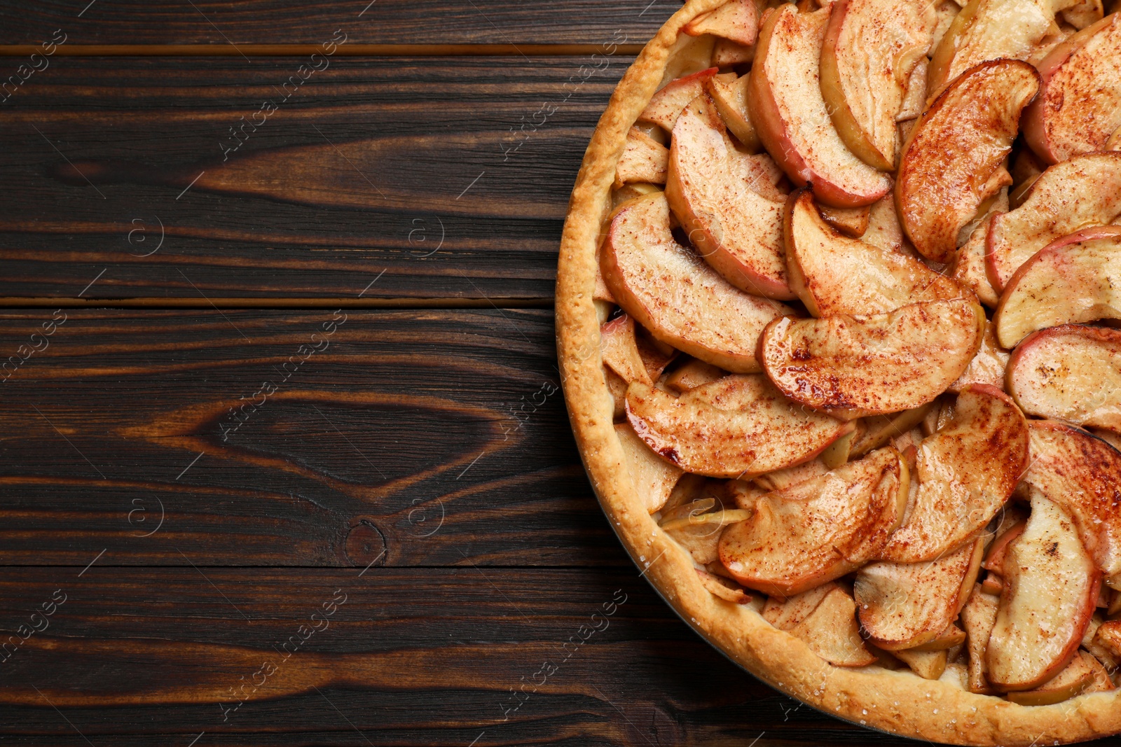 Photo of Delicious apple pie on wooden table, top view. Space for text