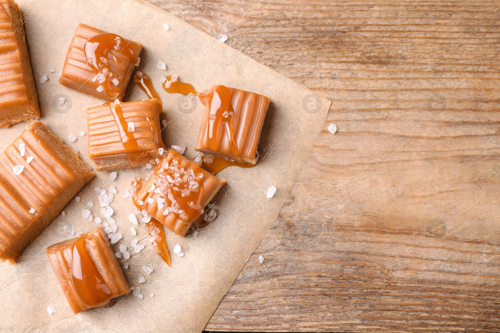 Photo of Salted caramel on wooden table, top view. Space for text