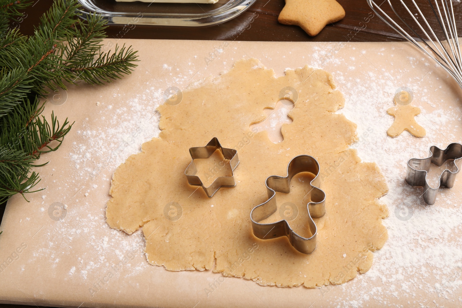 Photo of Making Christmas cookies. Raw dough and cutters on table