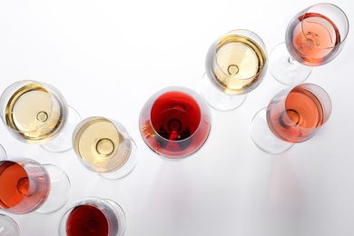 Different glasses with wine on white background, top view