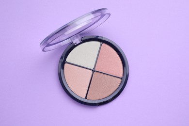 Photo of Colorful contouring palette on violet background, top view. Professional cosmetic product