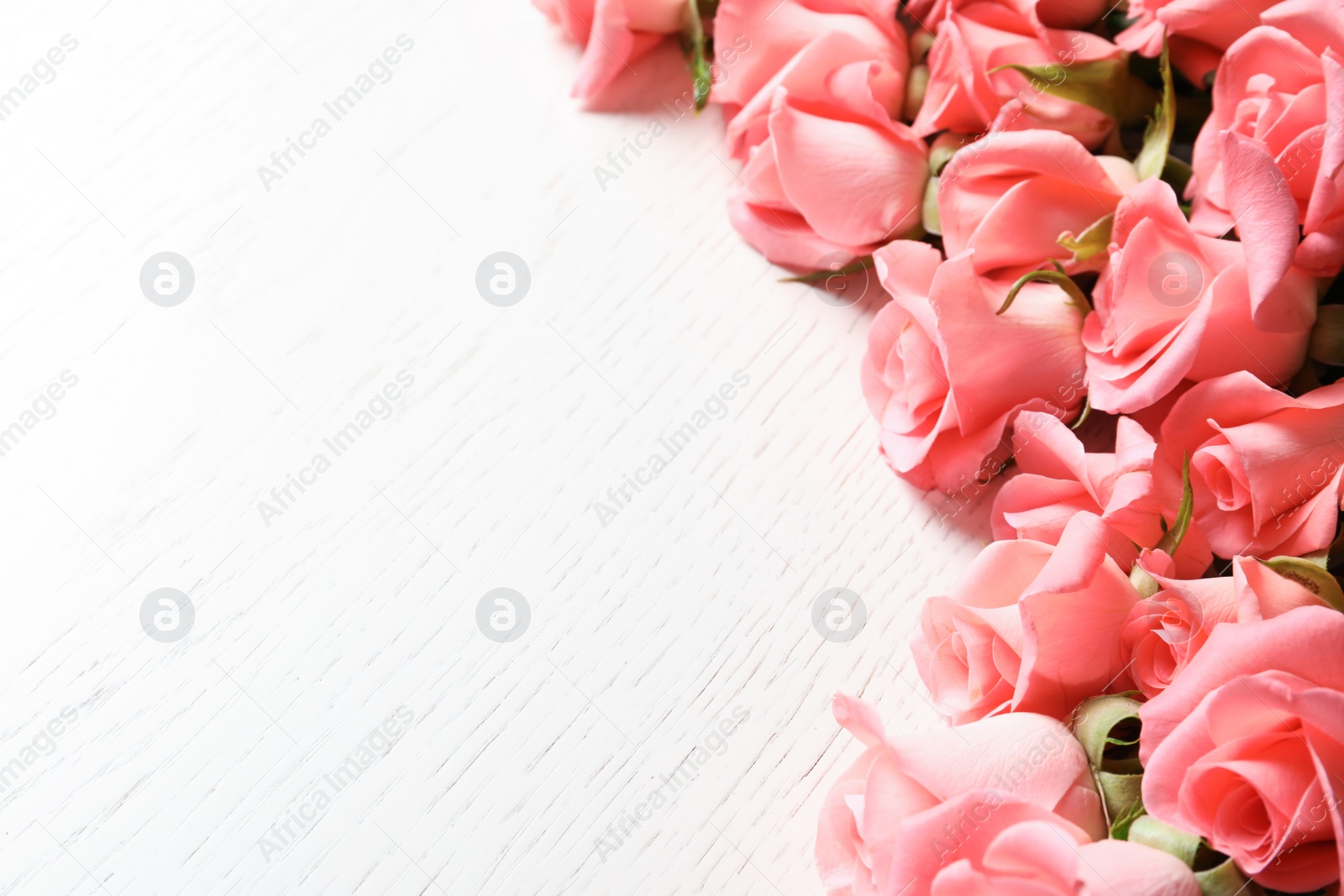 Photo of Beautiful roses on wooden table