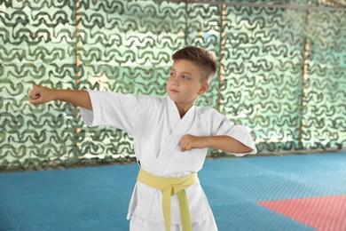 Boy in kimono practicing karate at outdoor gym