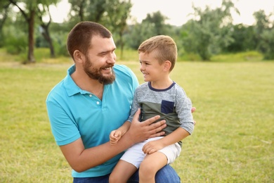 Photo of Man with his child outdoors. Happy family