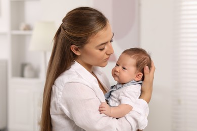 Mother holding her cute newborn baby at home