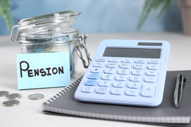 Calculator, money, notebook, pen and note with word Pension on white table, closeup. Retirement concept