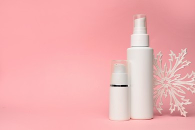 Photo of Winter skin care. Stylish presentation of hand cream sprays on pink background, space for text