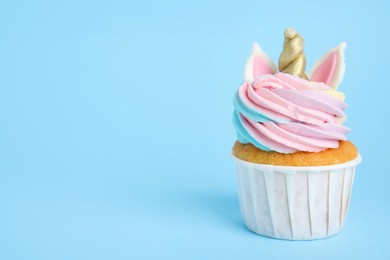 Cute sweet unicorn cupcake on light blue background. Space for text