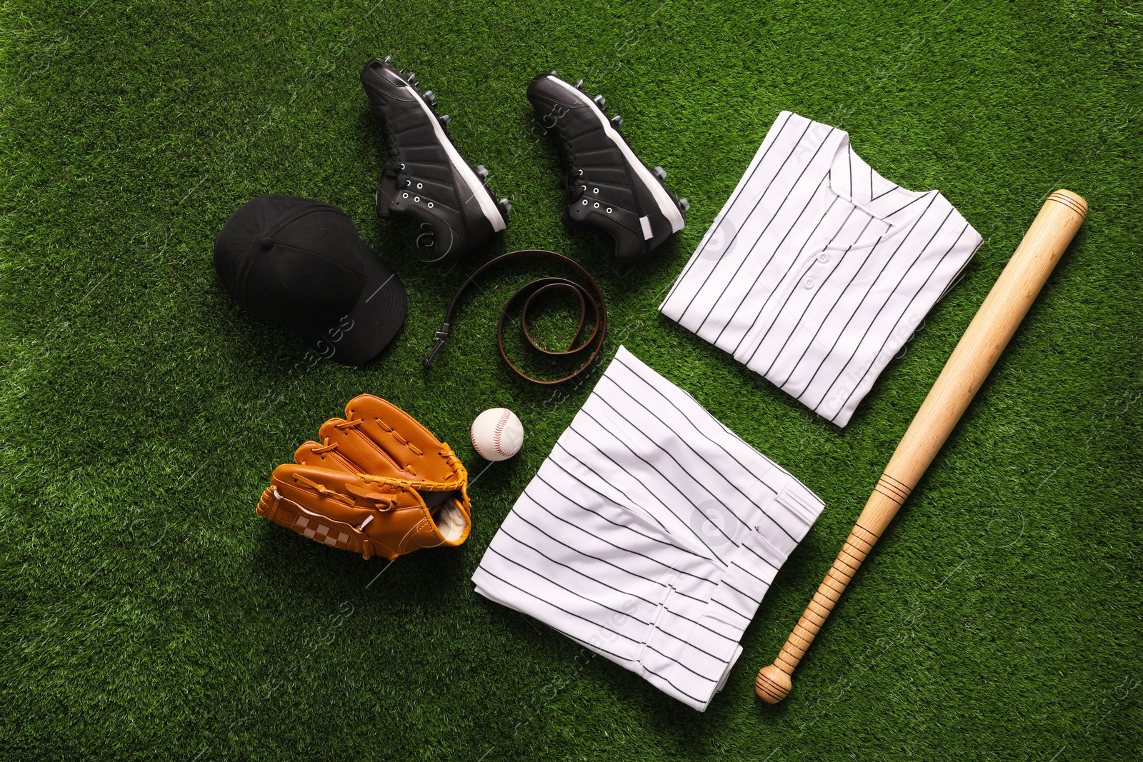 Photo of Flat lay composition with baseball equipment on artificial grass