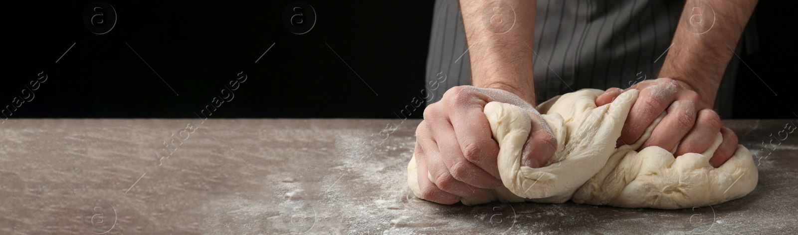 Image of Baker kneading dough at table, closeup with space for text. Banner design