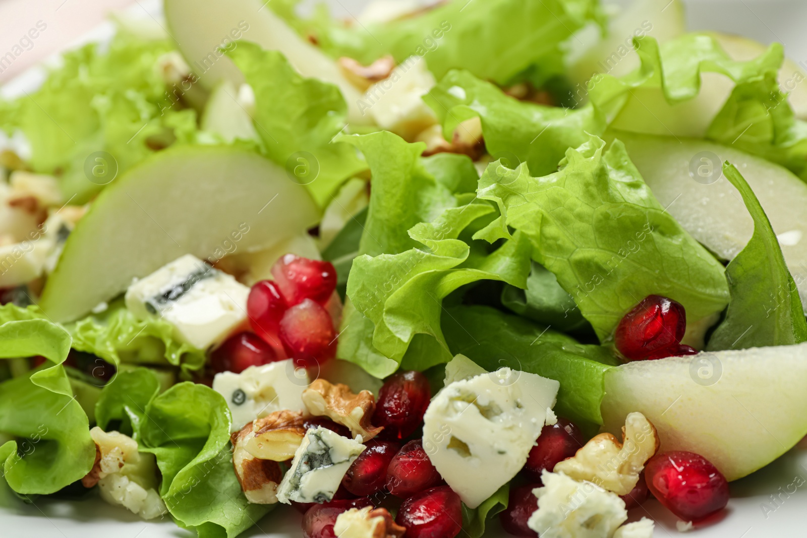 Photo of Tasty salad with pear slices, blue cheese and pomegranate seeds as background, closeup