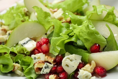Photo of Tasty salad with pear slices, blue cheese and pomegranate seeds as background, closeup