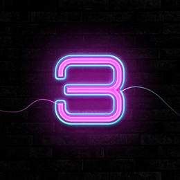 Image of Glowing neon number 3 sign on brick wall