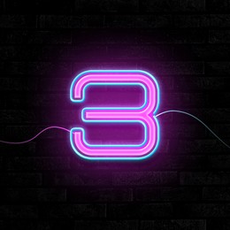 Glowing neon number 3 sign on brick wall