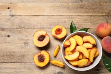 Photo of Cut juicy peaches on wooden table, flat lay. Space for text