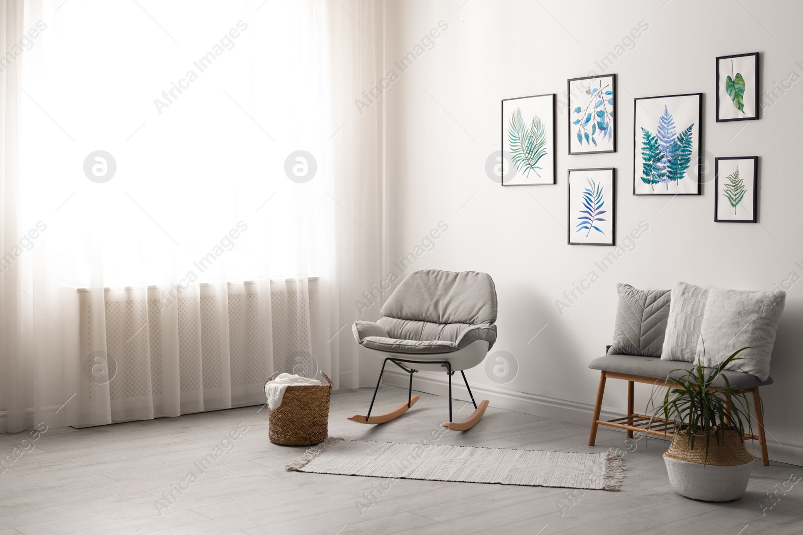 Photo of Beautiful paintings of tropical leaves on white wall in living room interior