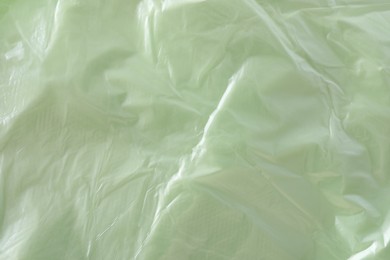 Photo of Texture of light green plastic bag as background, closeup