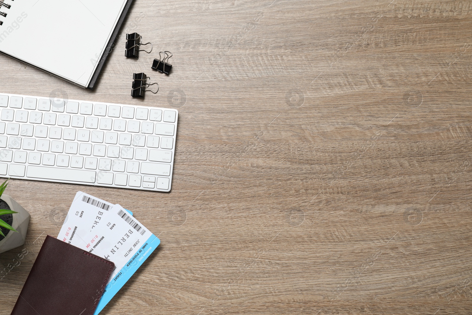 Photo of Flat lay composition with tickets, passport and keyboard on wooden table, space for text. Business trip