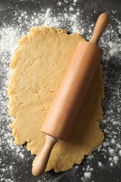 Making shortcrust pastry. Raw dough, flour and rolling pin on grey table, top view