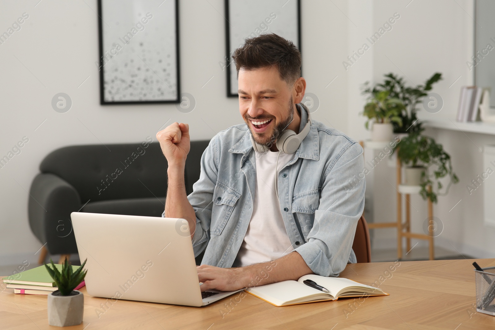 Photo of Online translation course. Happy man near laptop at home