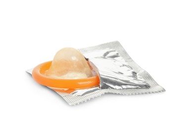 Photo of Unpacked orange condom isolated on white. Safe sex