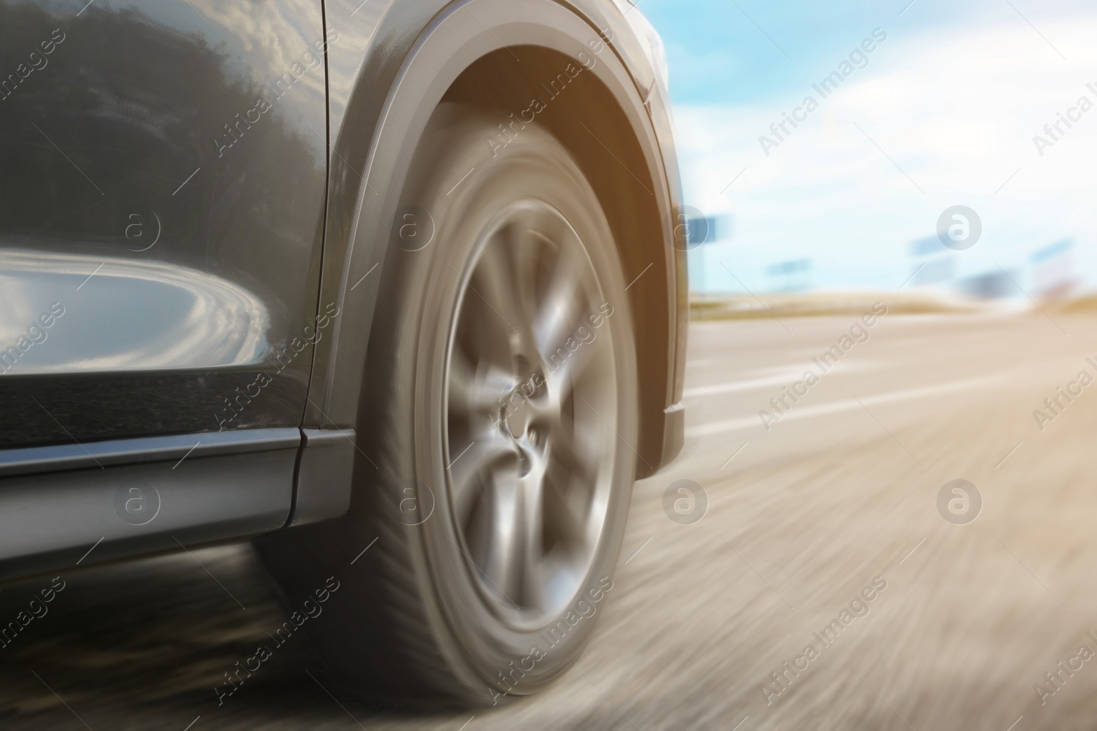 Image of Black car driving on road outdoors, closeup with motion blur effect. Space for text