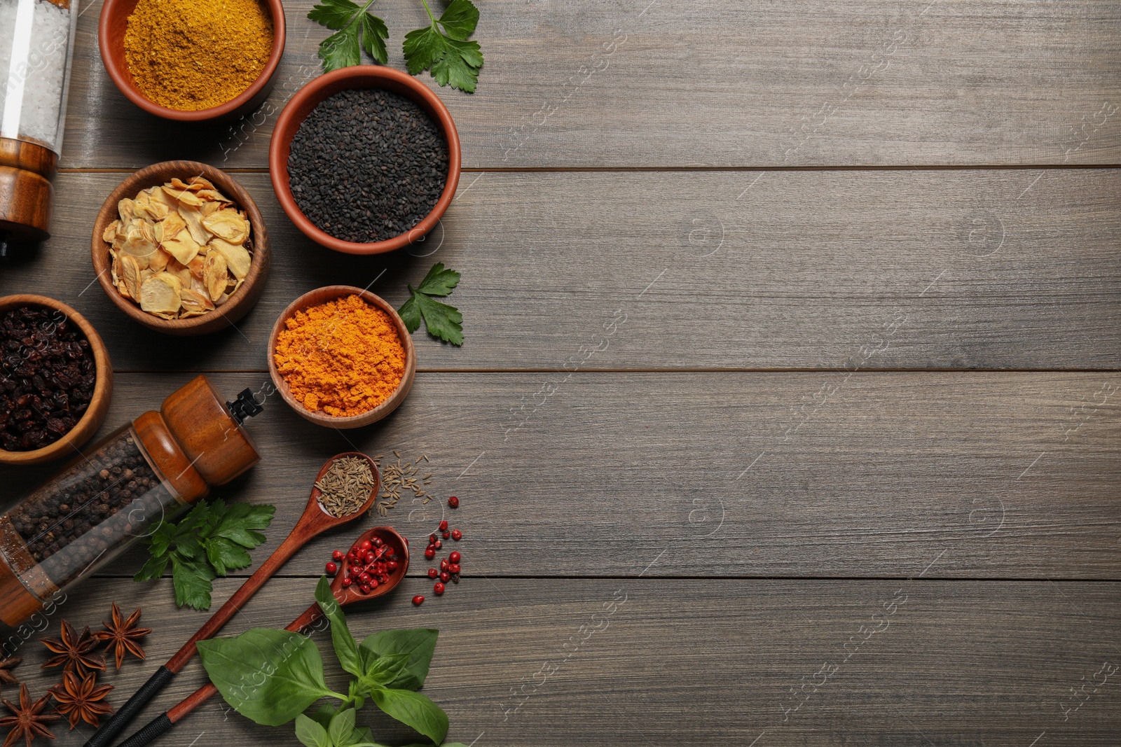 Photo of Flat lay composition with different spices on grey wooden table. Space for text